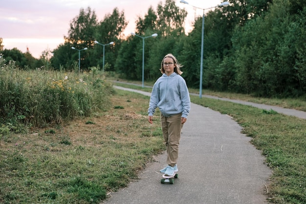 Adorable fille heureuse faisant du skateboard dans le parc