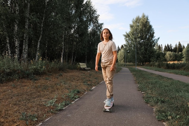 Adorable fille heureuse faisant du skateboard dans le parc