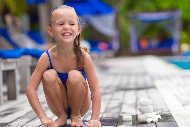 Adorable fille heureuse près de la piscine