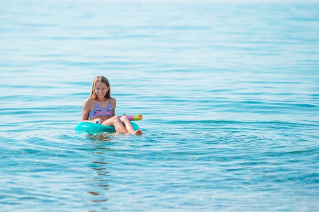 Adorable fille sur matelas pneumatique gonflable dans la mer