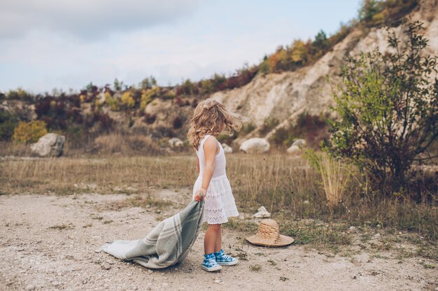 Adorable fille reste couverte de couverture dans le parc