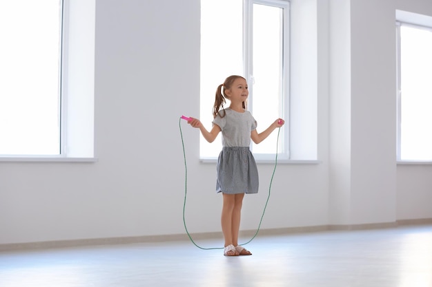 Adorable fille sautant à la corde à l'intérieur