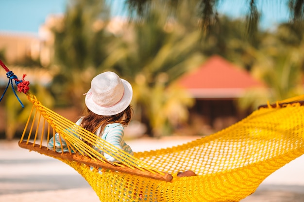 Adorable fille en vacances tropicales se détendre dans un hamac
