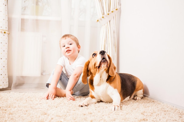 Adorable garçon de 3 ans joue avec son chien beagle