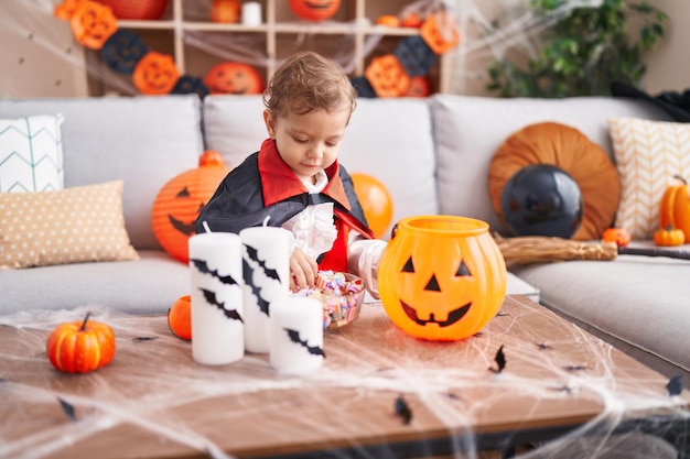 Adorable garçon caucasien ayant une fête d'halloween tenant des bonbons à la maison