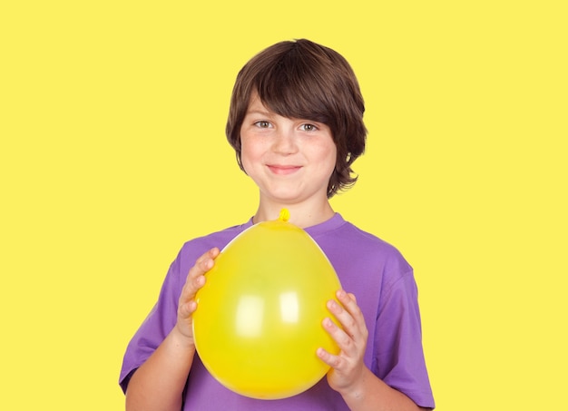 Adorable garçon preteen avec un ballon jaune