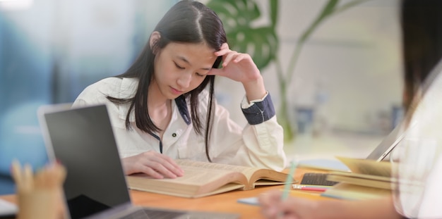 Adorable jeune Asiatique étudiant avec un ami