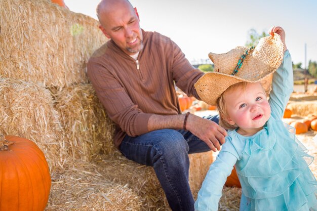 Une adorable jeune famille profite d'une journée au champ de citrouilles