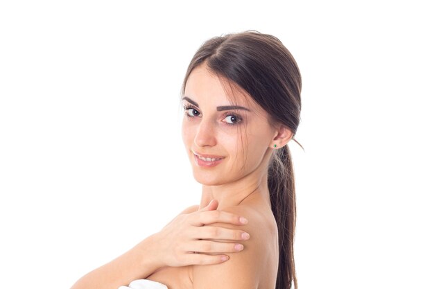 Adorable jeune fille prend soin de sa peau isolée sur fond blanc. Concept de soins de santé. Notion de soins du corps. Jeune femme avec une peau saine.