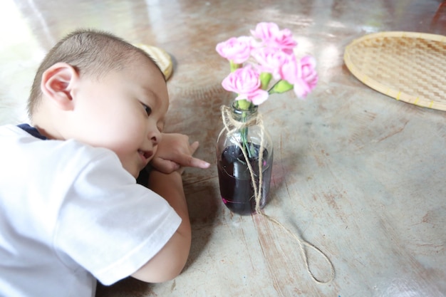 Adorable jeune garçon asiatique faisant un bouquet de fleurs à la maison.