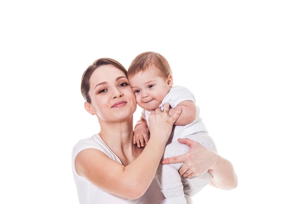 Adorable jeune mère et enfant regardant la caméra. Portrait sur le fond blanc