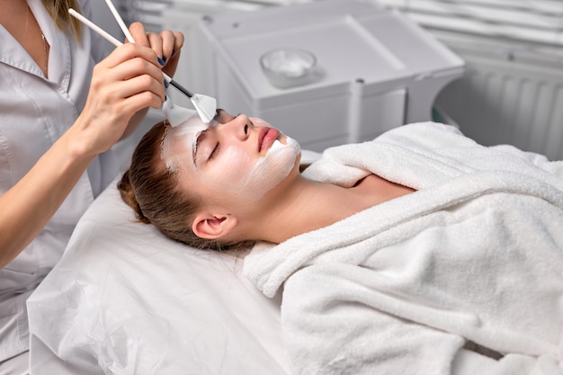 Photo adorable jolie femme allongée sur un canapé détendue traitée par un cosmétologue