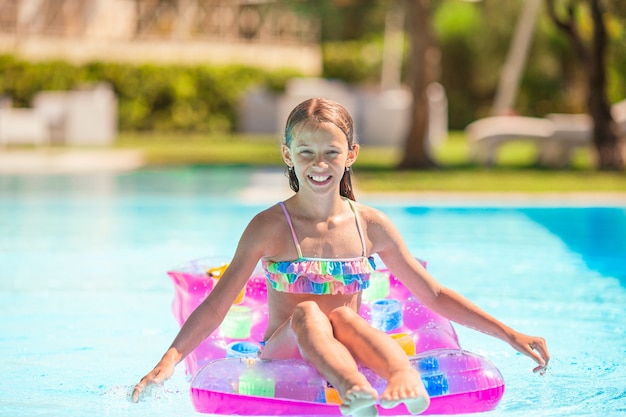 Adorable petit enfant joue dans la piscine extérieure