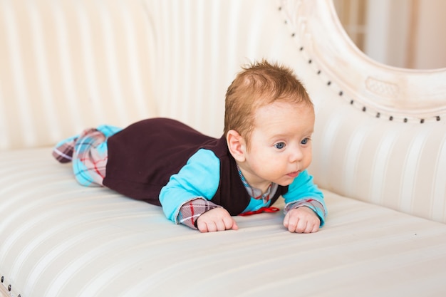 Adorable petit garçon allongé sur le ventre dans la chambre