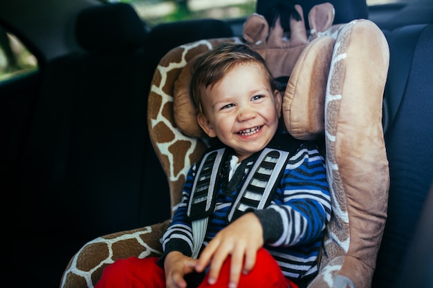 Adorable petit garçon assis dans un siège auto.