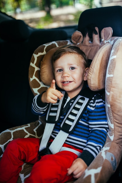 Adorable petit garçon dans un siège auto de sécurité.