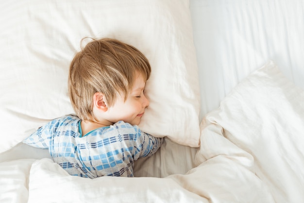 Adorable petit garçon endormi dans son lit