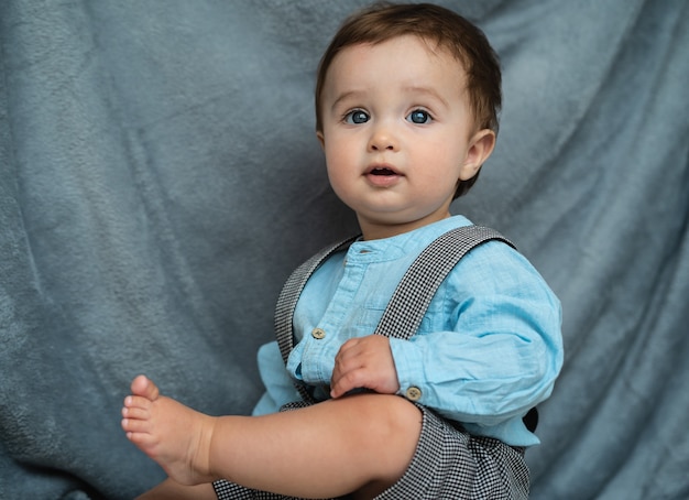 L'adorable petit garçon est assis par terre