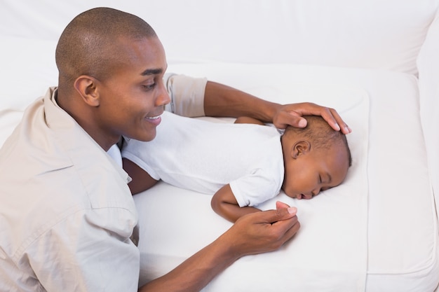 Adorable petit garçon qui dort tout en étant surveillé par son père