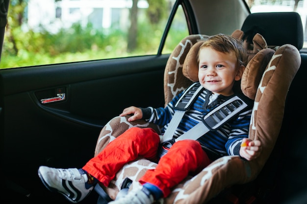 Adorable petit garçon en siège auto de sécurité