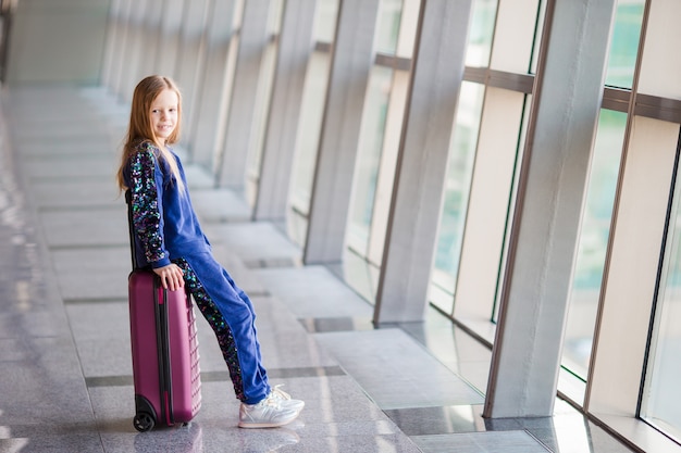 Adorable petite fille à l'aéroport près d'une grande fenêtre