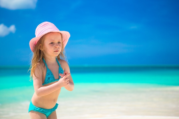 Adorable petite fille au chapeau sur la plage pendant les vacances des Caraïbes