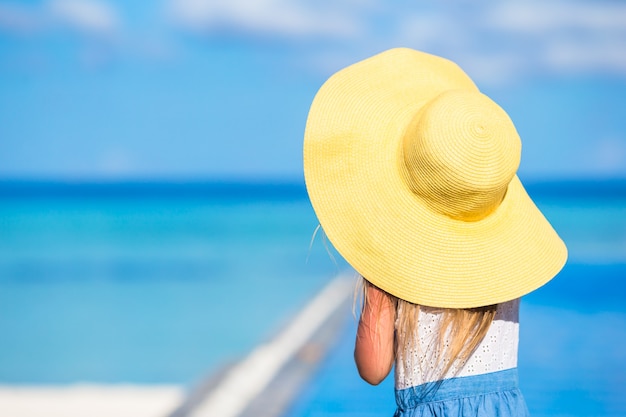 Adorable petite fille au grand chapeau jaune pendant les vacances d'été