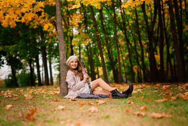 Adorable petite fille aux feuilles d'automne dans le parc de beauté