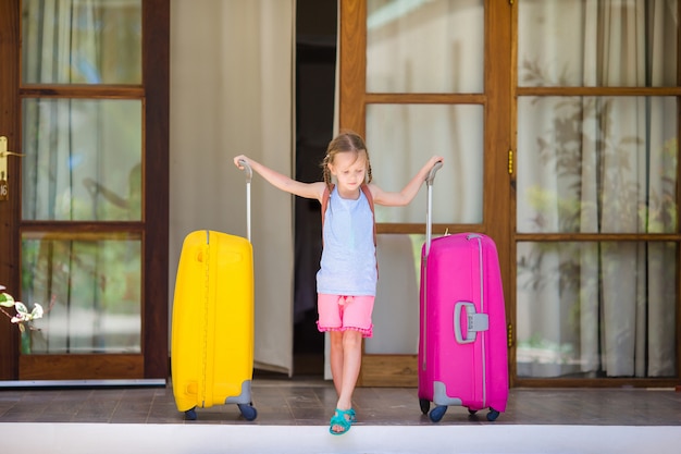 Adorable petite fille avec des bagages prêts à voyager