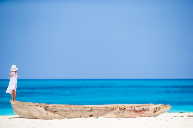 Adorable petite fille sur un bateau sur le rivage