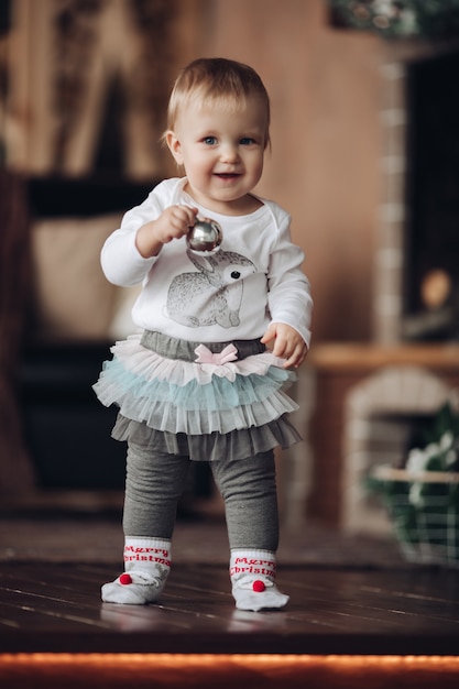 Adorable petite fille avec une boule de Noël en argent