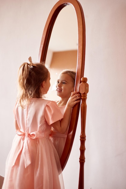 Adorable petite fille caucasienne regardant dans le miroir