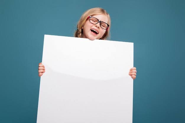 Adorable Petite Fille En Chemise Rose, Pantalon Noir Et Lunettes Tient Affiche Vide