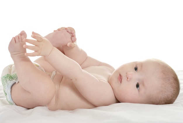 Adorable petite fille couchée dans pampers sur couverture sur fond blanc