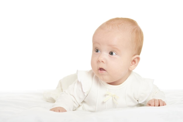 Adorable petite fille sur couverture sur fond blanc