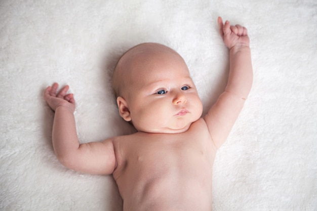 Adorable petite fille sur une couverture en tricot blanc