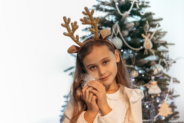 Adorable petite fille décorant le sapin de Noël à la maison