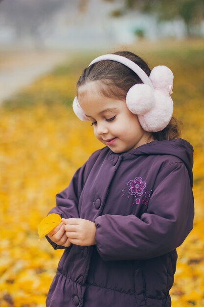 Adorable petite fille drôle dans le parc par une belle journée d'automne.