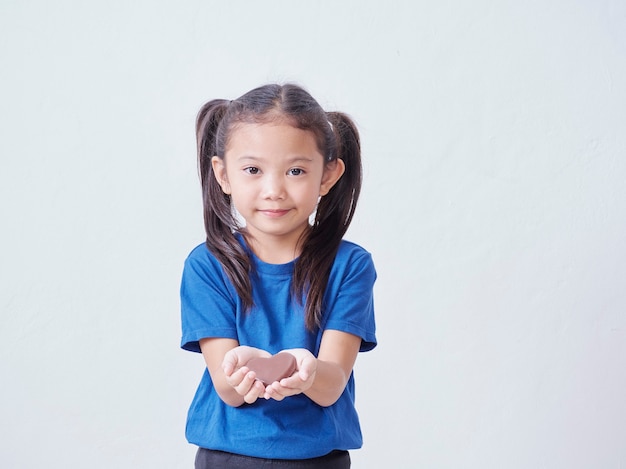 Adorable petite fille avec du chocolat en forme de coeur isolé