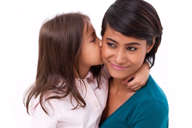 Adorable petite fille embrassant la joue de sa mère