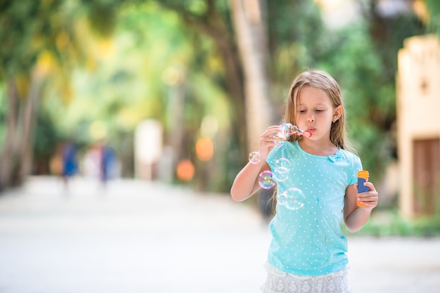 Adorable petite fille faisant des bulles de savon pendant les vacances d'été