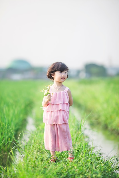 Adorable petite fille avec des fleurs dans la main