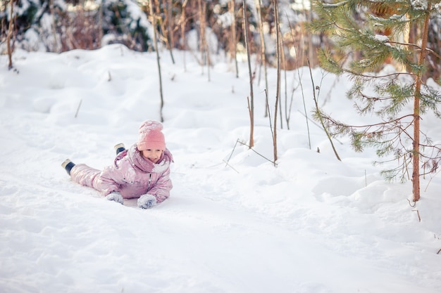 Adorable petite fille heureuse, traîneau à chiens en journée d'hiver enneigée.