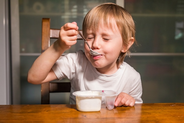 Adorable petite fille mangeant du fromage cottage avec une cuillère