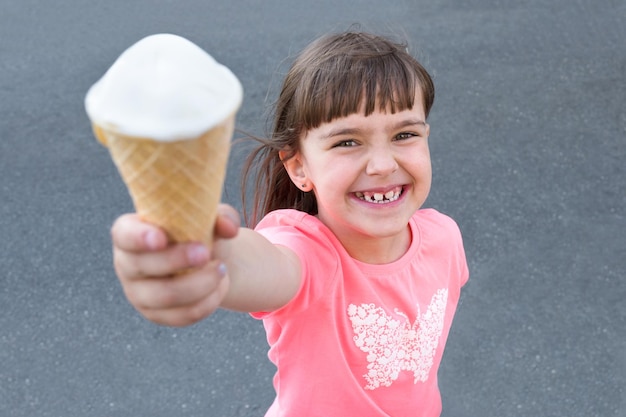 Adorable petite fille mangeant des glaces à l'extérieur en été dans la ville