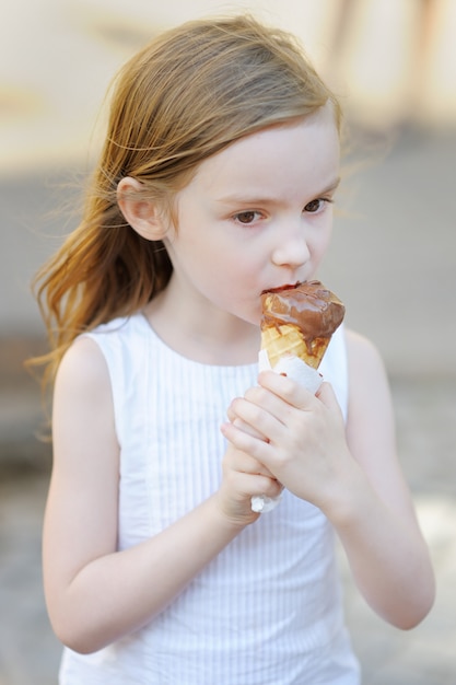 Adorable petite fille mangeant des glaces en plein air en été