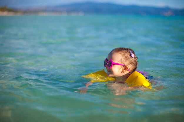 Adorable petite fille à la mer en vacances à la plage tropicale