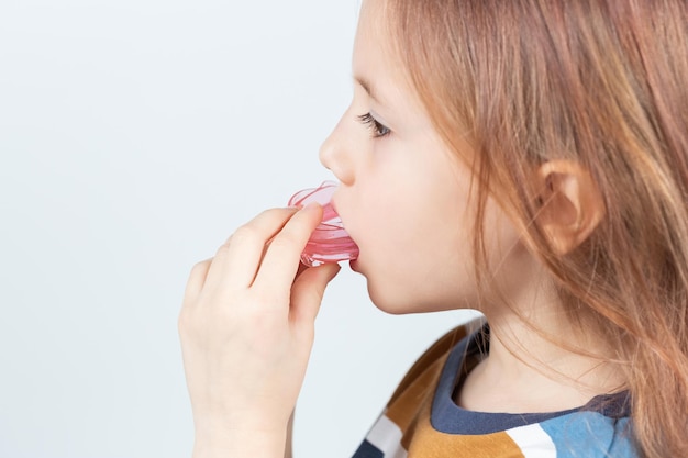 Adorable petite fille met un entraîneur myofonctionnel dans la bouche