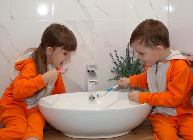 Adorable Petite Fille Mignonne Tenant Une Brosse à Dents Et Se Brossant Les Dents Dans La Salle De Bain. L'enfant Apprend à Rester En Bonne Santé. Hygiène Saine Du Matin Pour Les Enfants.