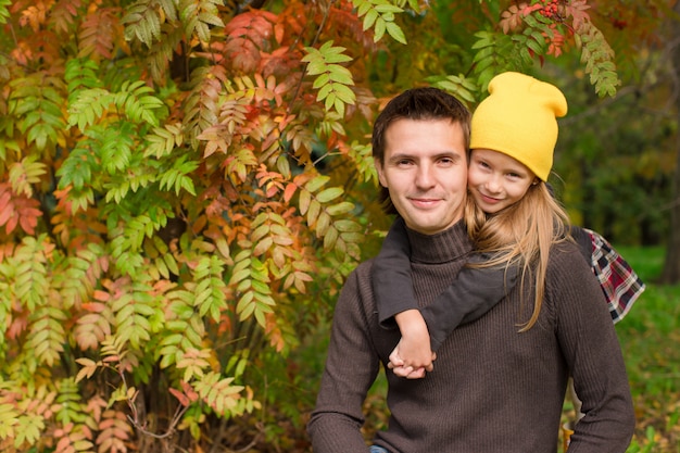 Adorable petite fille avec un père heureux s'amuser dans un parc d'automne